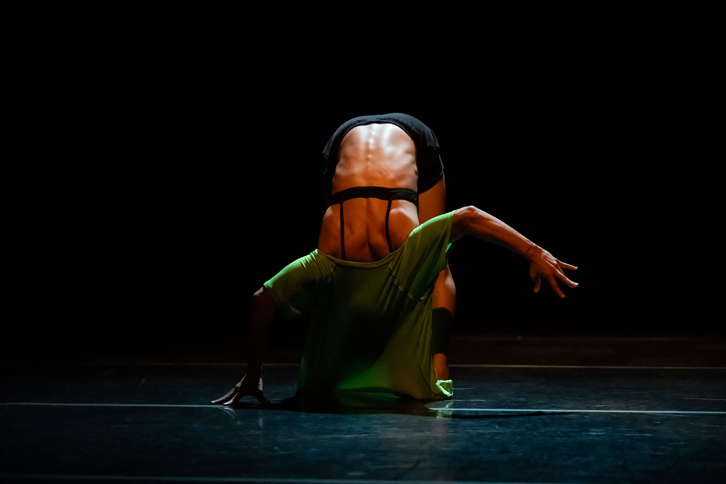 Union PDX - Festival:23 artist Evelyn Tejeda performing her work '0.4mm'. Photo depicts Evelyn bent over contorted in a green shirt. | Photography: Jingzi Zhao